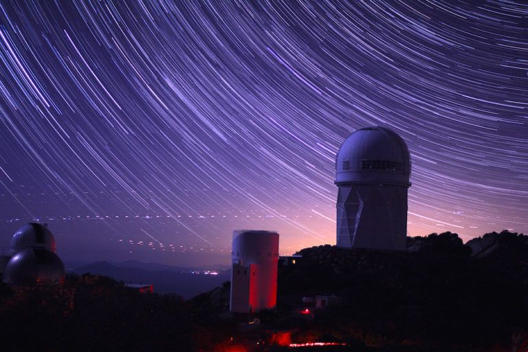 Star trails take shape around the 14-story Mayall Telescope dome in a long-exposure image
