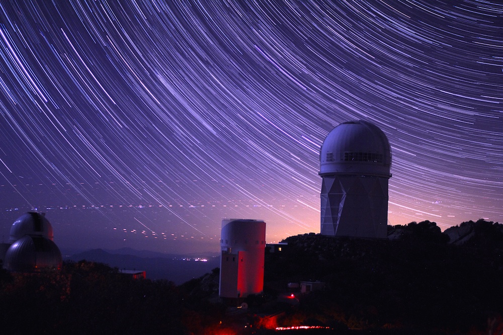 Une photo à longue exposition montre des traces d’étoiles qui entourent le dôme du télescope Mayall, d’une hauteur de 14 étages.