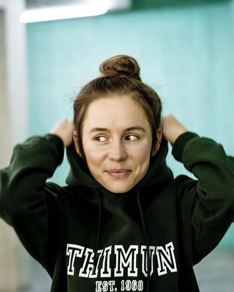 Portrait of a young woman wearing a dark green hoodie