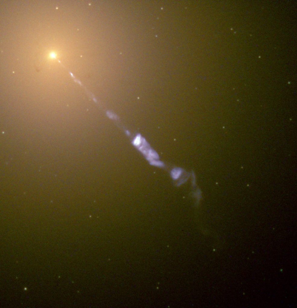 Image de l'un des jets issus de la galaxie M87. Dans le coin supérieur gauche, on voit un amas d'étoiles ressemblant à un point brillant, et un jet étroit bleuâtre s'étend en direction du coin inférieur droit.