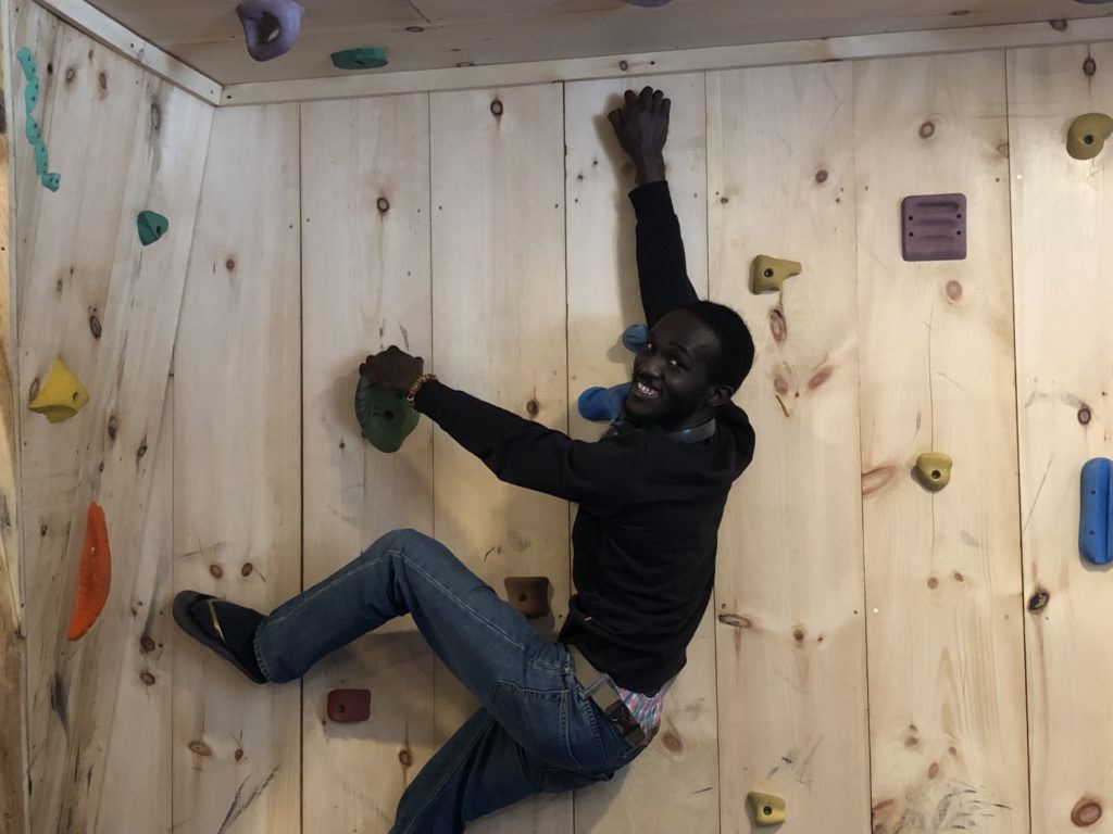 Le chercheur Seth Asante grimpe sur un mur d’escalade au camp de gravitation quantique