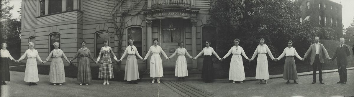 A black and white image of group of women stand holding hands in the style of a chain of paper dolls
