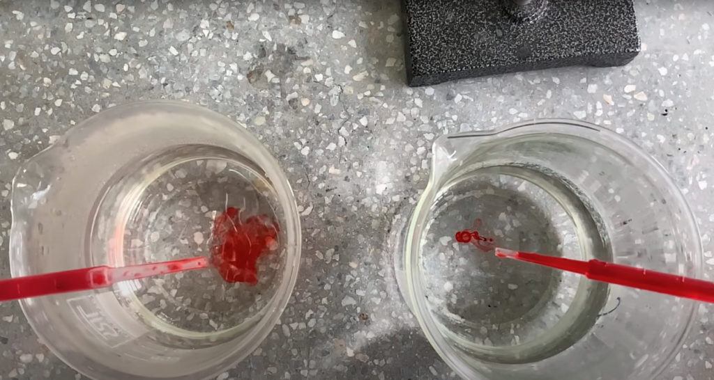 Two beakers of water with drops of red food colouring in water