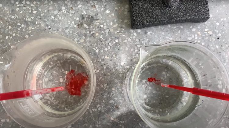 Two beakers of water with drops of red food colouring in water