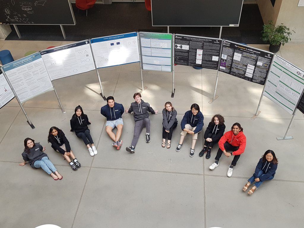 Aerial shot of a group of students sitting on the floor in a semi circle