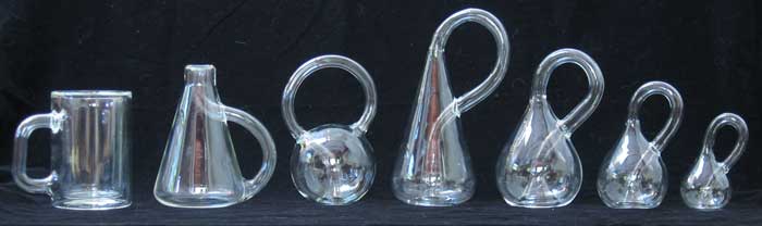Seven different shaped glass bottles with glass handles